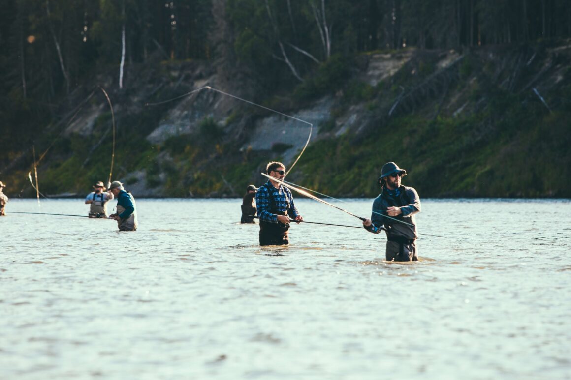 A group of men fly-fishing in a river in Asheville, NC.